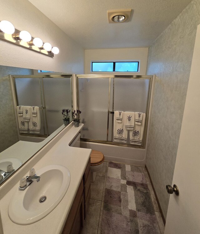3671 Santa Rosa Way, Redding, CA 96003 - bathroom featuring a textured wall, vanity, toilet, and bath / shower combo with glass door