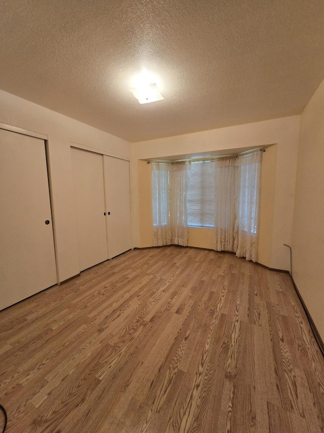 3671 Santa Rosa Way, Redding, CA 96003 - unfurnished bedroom with two closets, wood finished floors, and a textured ceiling