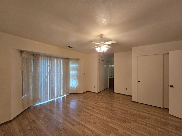 3671 Santa Rosa Way, Redding, CA 96003 - unfurnished bedroom featuring a ceiling fan, wood finished floors, visible vents, and a textured ceiling