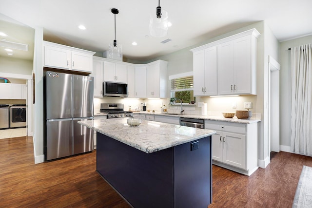 22070 Lassen View Dr, Palo Cedro, CA 96073 - kitchen featuring washing machine and clothes dryer, stainless steel appliances, a sink, and white cabinetry