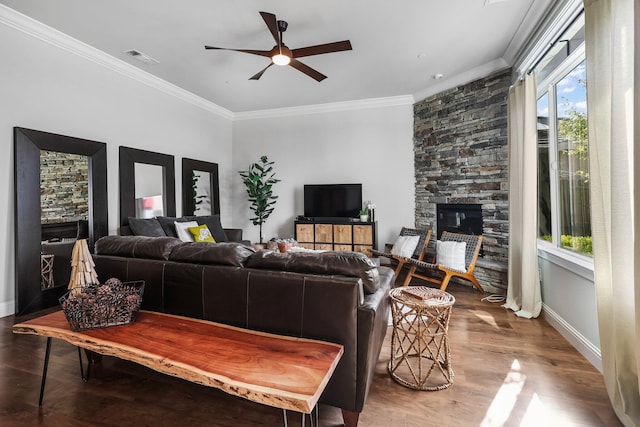 living room with a stone fireplace, ceiling fan, a wealth of natural light, and visible vents