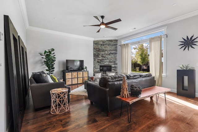 living room featuring crown molding, ceiling fan, a fireplace, wood finished floors, and visible vents