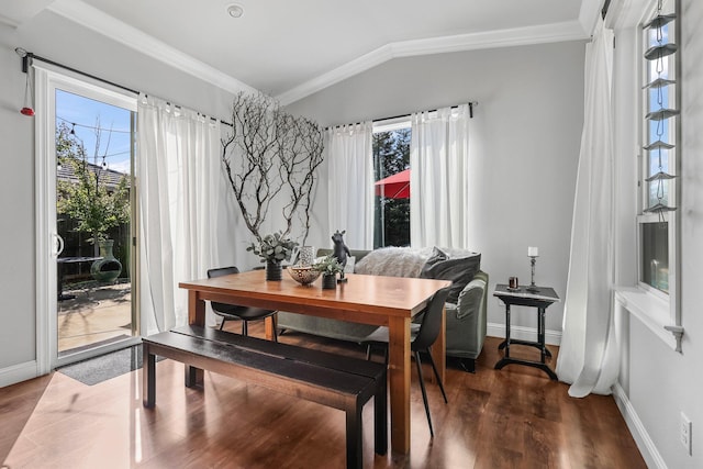 dining area with baseboards, ornamental molding, lofted ceiling, and dark wood-style floors