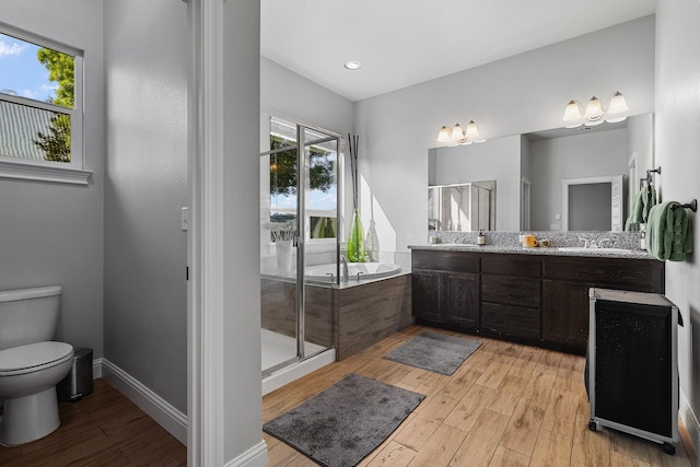 full bath featuring a garden tub, hardwood / wood-style flooring, toilet, and a shower stall
