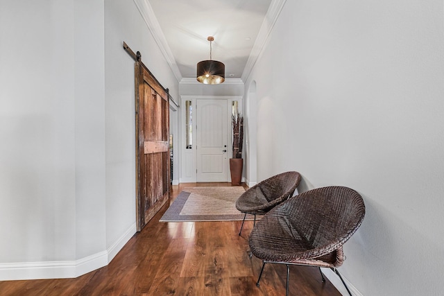 hallway with baseboards, a barn door, wood finished floors, and ornamental molding
