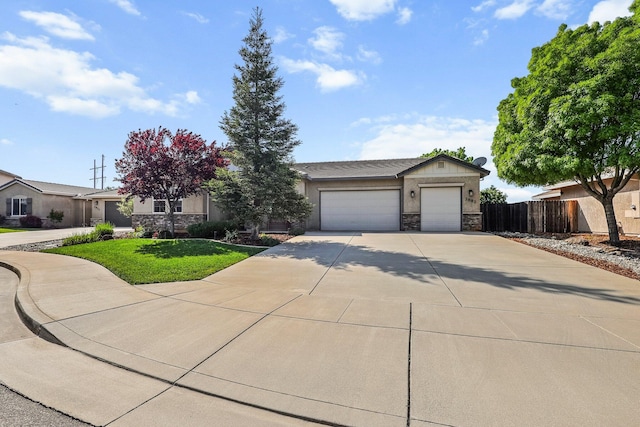 view of front of home featuring fence, a garage, driveway, and stone siding