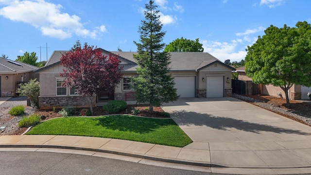 view of front of house with fence, stone siding, a tiled roof, concrete driveway, and an attached garage