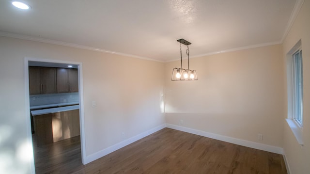 empty room featuring baseboards, ornamental molding, wood finished floors, and recessed lighting