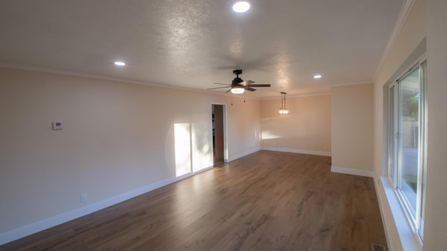 empty room with recessed lighting, wood finished floors, ornamental molding, baseboards, and ceiling fan