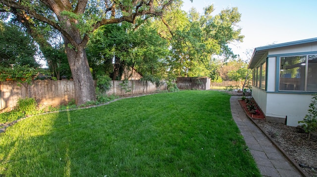 view of yard with a fenced backyard and a sunroom