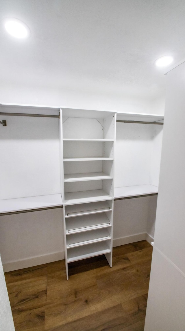 walk in closet with wood finished floors