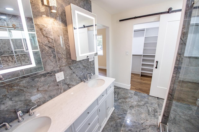 full bathroom with a walk in closet, decorative backsplash, a sink, and double vanity