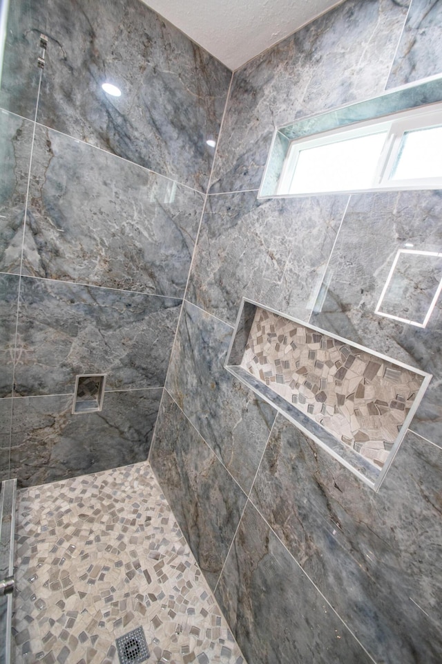 interior details with a tile shower