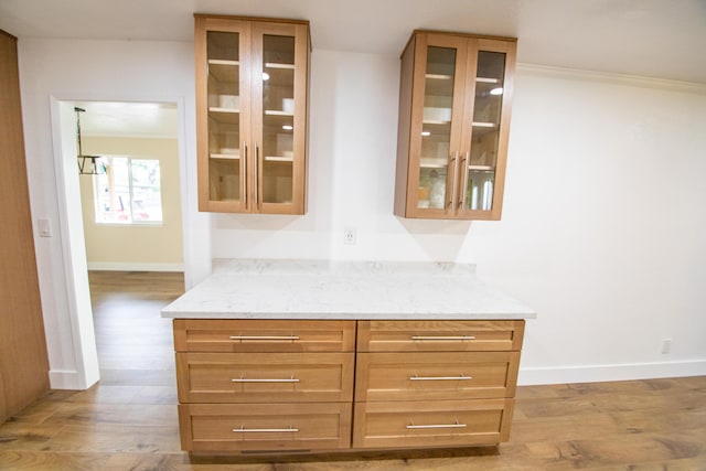 interior space featuring light wood-style flooring, baseboards, and ornamental molding