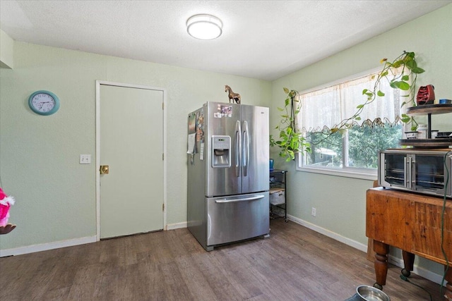 19715 Reed Rd, Cottonwood, CA 96022 - kitchen featuring stainless steel refrigerator with ice dispenser, wood finished floors, and baseboards