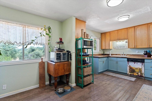 19715 Reed Rd, Cottonwood, CA 96022 - kitchen featuring dishwasher, stainless steel microwave, dark wood-style floors, healthy amount of natural light, and a textured ceiling