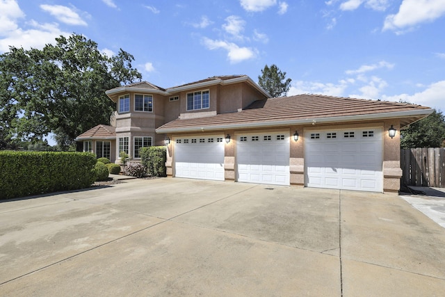 20340 Greenview Dr, Redding, CA 96002 - view of front facade featuring stucco siding, a tiled roof, driveway, fence, and a garage