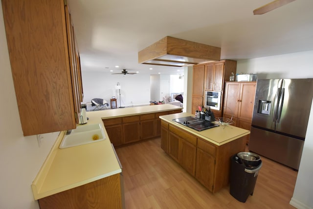 kitchen with light wood-style floors, light countertops, appliances with stainless steel finishes, and ceiling fan