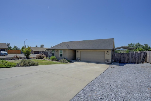 3503 Americana Way, Redding, CA 96003 - ranch-style house with fence, a front lawn, concrete driveway, an attached garage, and stone siding