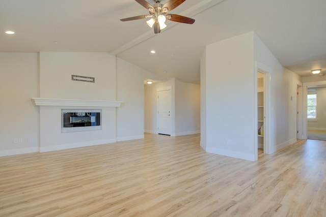 3503 Americana Way, Redding, CA 96003 - unfurnished living room with a glass covered fireplace, light wood-style floors, vaulted ceiling with beams, ceiling fan, and baseboards