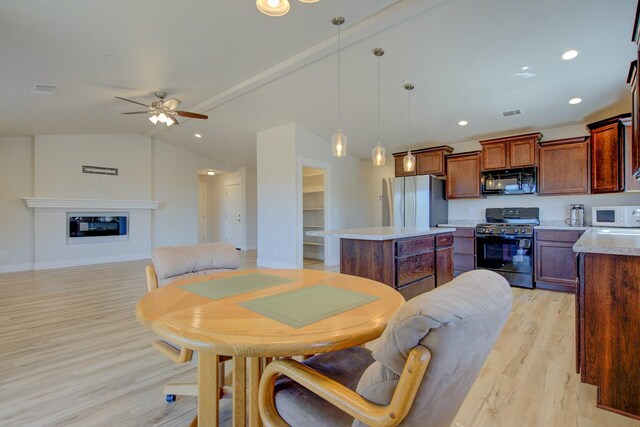 3503 Americana Way, Redding, CA 96003 - dining area with lofted ceiling, visible vents, a ceiling fan, a glass covered fireplace, and light wood-style flooring