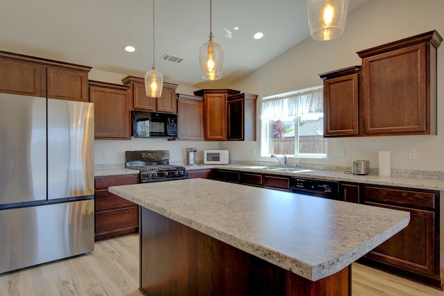 3503 Americana Way, Redding, CA 96003 - kitchen with visible vents, a sink, light wood-style floors, a center island, and black appliances