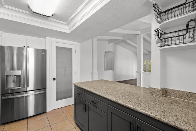 2633 Forest Ct, Redding, CA 96002 - kitchen featuring stainless steel fridge, light stone counters, white cabinets, decorative columns, and light tile patterned floors