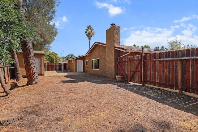 2633 Forest Ct, Redding, CA 96002 - back of property with a chimney, a fenced backyard, stucco siding, and a tiled roof