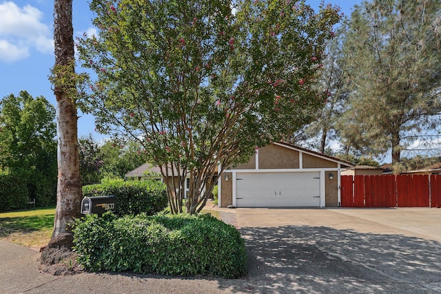 2633 Forest Ct, Redding, CA 96002 - view of property hidden behind natural elements featuring concrete driveway, stucco siding, and a garage