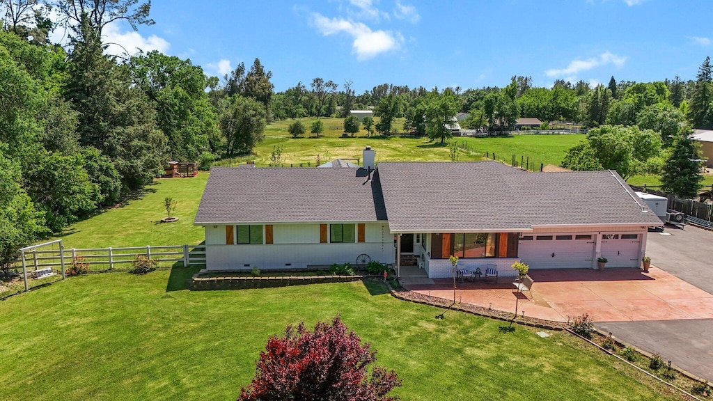 view of front of home with an attached garage, fence, driveway, and a front yard