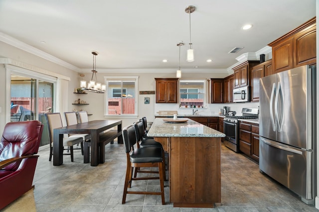5538 Muir Peak Rd, Redding, CA 96002 - kitchen with light stone counters, a chandelier, stainless steel appliances, decorative light fixtures, and a center island