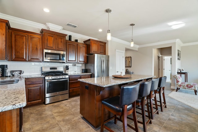 5538 Muir Peak Rd, Redding, CA 96002 - kitchen featuring appliances with stainless steel finishes, visible vents, ornamental molding, and a center island