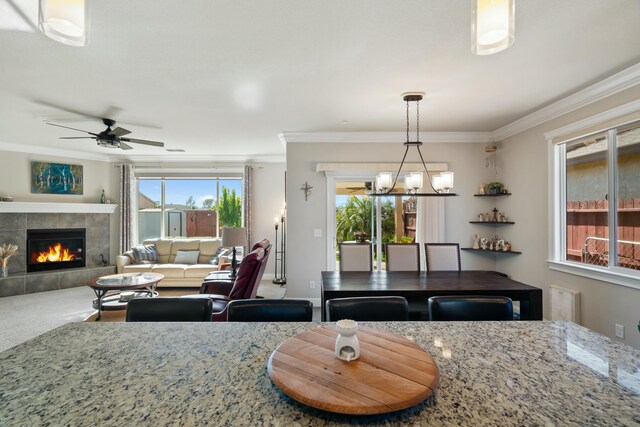 5538 Muir Peak Rd, Redding, CA 96002 - dining area with ornamental molding, a tile fireplace, carpet floors, and ceiling fan with notable chandelier