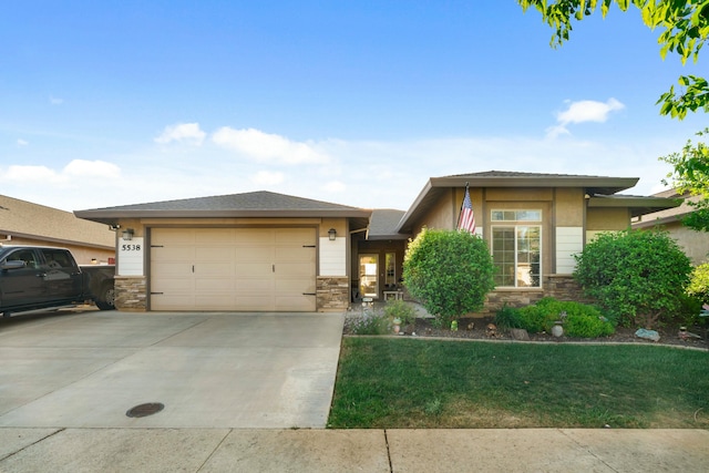 5538 Muir Peak Rd, Redding, CA 96002 - prairie-style home with a front yard, concrete driveway, stone siding, and an attached garage