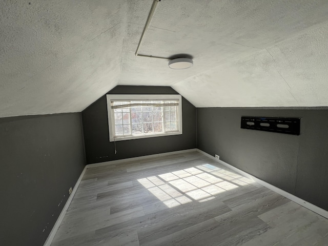 36770 Woods Ave, Burney, CA 96013 - additional living space featuring a textured ceiling, wood finished floors, baseboards, and lofted ceiling