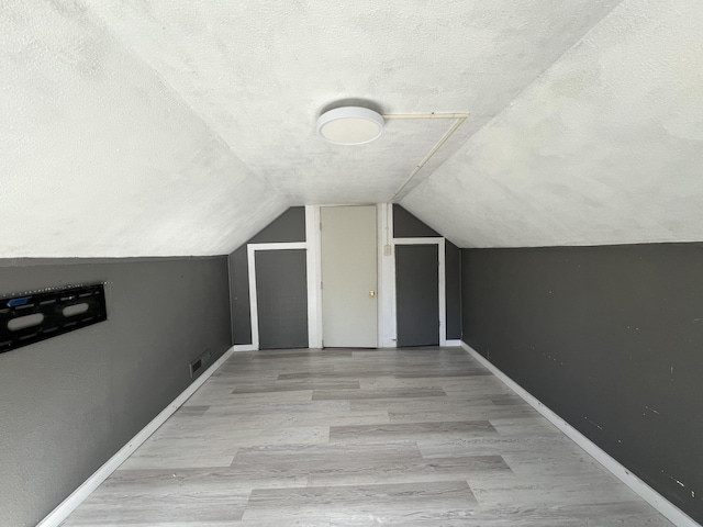 36770 Woods Ave, Burney, CA 96013 - bonus room with a textured ceiling, lofted ceiling, wood finished floors, and baseboards