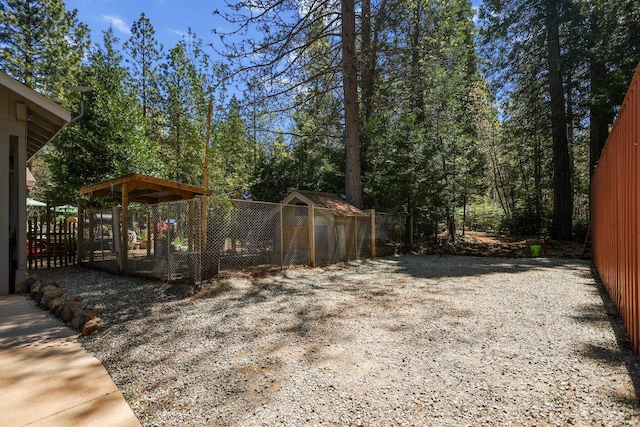 view of yard featuring an outbuilding, exterior structure, and fence