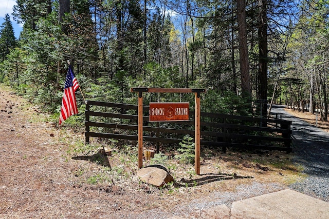 exterior space with fence and a wooded view
