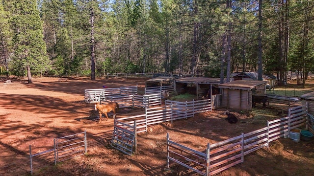 view of yard featuring an exterior structure, an outbuilding, and a view of trees