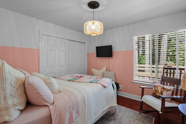 bedroom with baseboards, wood finished floors, and a closet