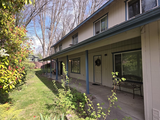 view of side of property featuring a patio and a yard