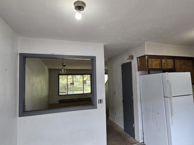 kitchen featuring freestanding refrigerator and dark brown cabinets