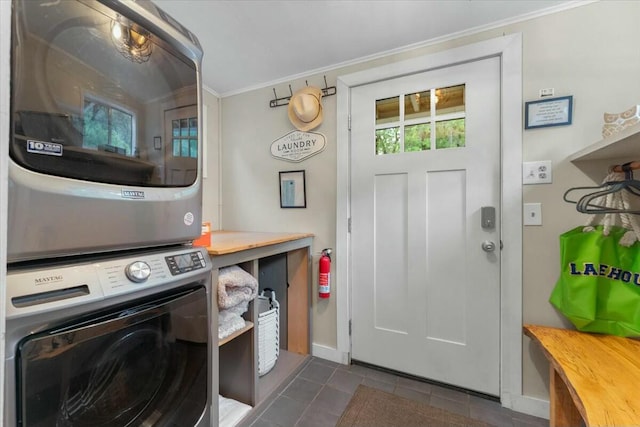 19817 Oak Knoll Dr, Lakehead, CA 96051 - laundry area with stacked washer and clothes dryer, baseboards, ornamental molding, dark tile patterned floors, and laundry area