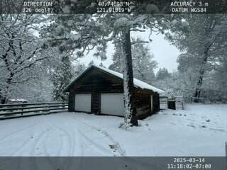 snow covered property featuring an outbuilding and a garage
