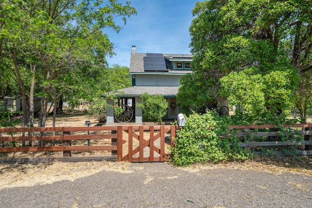 24294 Dersch Rd, Anderson, CA 96007 - view of front of home with a fenced front yard, a chimney, roof mounted solar panels, roof with shingles, and a gate