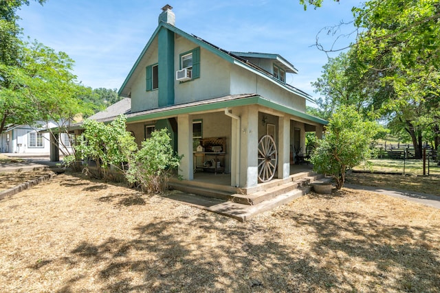 24294 Dersch Rd, Anderson, CA 96007 - view of front of house with stucco siding, a chimney, fence, and covered porch