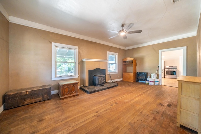 24294 Dersch Rd, Anderson, CA 96007 - living room with a wood stove, a ceiling fan, wood-type flooring, ornamental molding, and baseboards