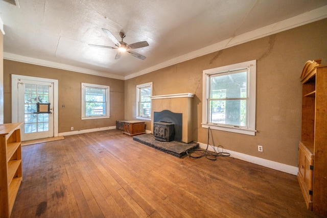 24294 Dersch Rd, Anderson, CA 96007 - unfurnished living room featuring a wood stove, hardwood / wood-style flooring, baseboards, ceiling fan, and crown molding