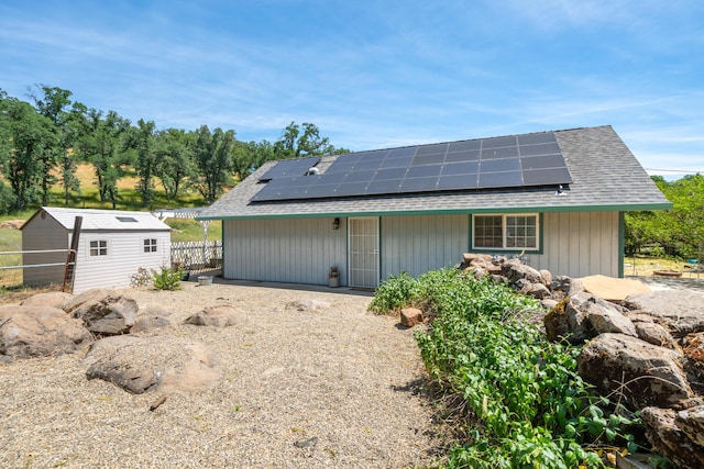 24294 Dersch Rd, Anderson, CA 96007 - back of property featuring roof mounted solar panels, an outdoor structure, fence, and a storage unit