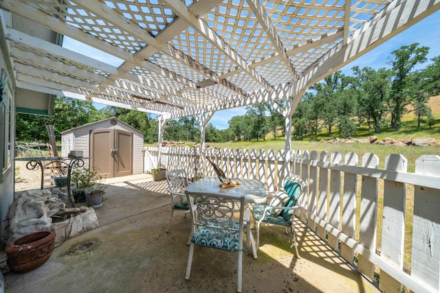 24294 Dersch Rd, Anderson, CA 96007 - view of patio / terrace featuring a storage unit, outdoor dining area, an outbuilding, fence, and a pergola
